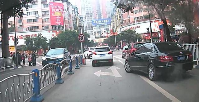 在路口实线区域变更车道的黑色轿车