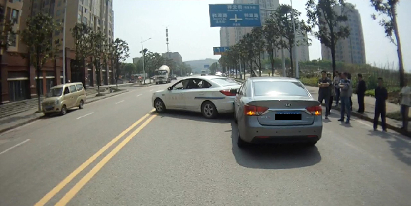 在双黄线路段掉头的白色轿车
